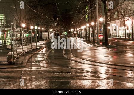 Nasse Trolleyschienen im Licht und auf den Straßen reflektieren das Licht Stockfoto