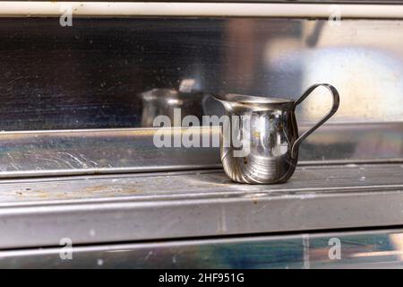 Edelstahlkaraffe zur Herstellung von Espresso-Getränken in einem Kaffeehaus Stockfoto