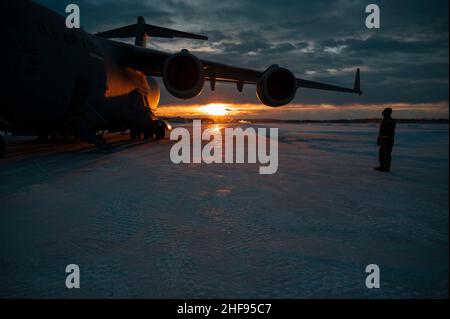 US Air Force Staff Sgt. Beaux Hebert, 354th Fighter Wing Public Affairs nicht kommissioniert und für die Medienoperationen zuständig, steht neben einem C-17 Globemaster III von der Joint Base Elmendorf-Richardson, Alaska, während er Fracht auf der Eielson Air Force Base, Alaska, am 11. Januar 2022 ablädt. Die C-17 führt häufig taktische und strategische Luftauftriebsmissionen durch und transportiert Truppen und Fracht auf der ganzen Welt; zusätzliche Rollen umfassen die medizinische Evakuierung und die Luftabtriebsaufgaben. (USA Luftwaffe Foto von Airman 1st Klasse Elizabeth Schoubroek) Stockfoto