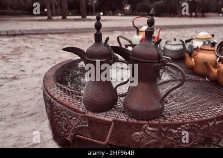 Traditionelle alte arabische Kaffeekannen am beduinenkamin in der Wüste.Kaffeekannen im Beduinenzelt im Nahen Osten. Stockfoto