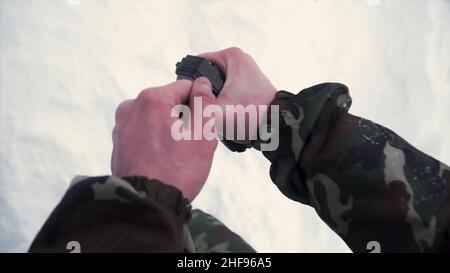 Der Soldat hält in seiner Hand eine Trainingsgranate, während er militärische Übungen in der Armee, Schnee Hintergrund. Ein Soldat in Tarnung mit einem Frag Stockfoto