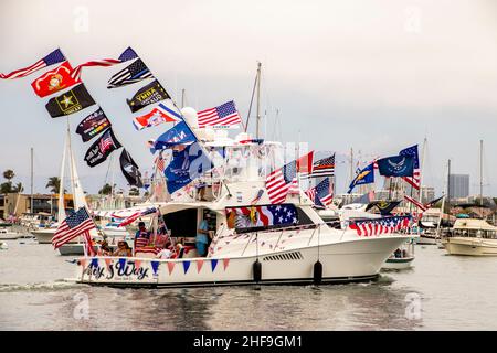 Mit Fahnen des US-Militärs und der US-Flagge geschmückt, feiert eine Yacht im Hafen von Newport Beach, CA, den 4. Juli. Stockfoto