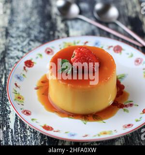 Hausgemachter Karamellpudding mit Erdbeer-Topping. Platz für Text kopieren Stockfoto