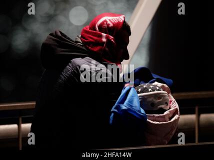 Ein Mann trägt ein Baby, da eine Gruppe von Menschen, die als Migranten gelten, nach Dover, Kent, gebracht wird, nachdem sie von der RNLI nach einem kleinen Bootsunfall im Kanal gerettet wurde. Bilddatum: Samstag, 15. Januar 2022. Stockfoto