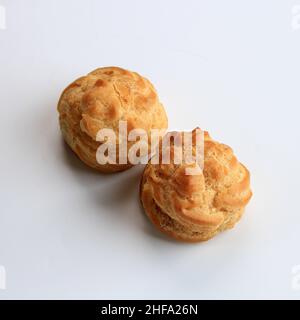 Zwei Choux Creme auf weißem Hintergrund. Profiterole, Eclair, Cremepuff. Isoliert Stockfoto