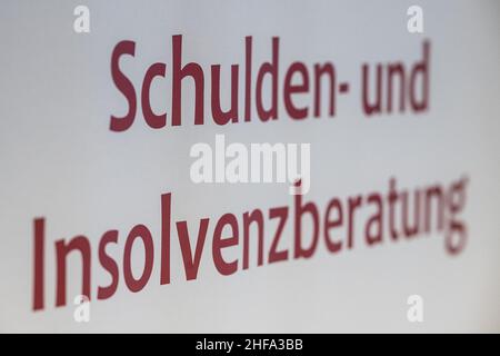 PRODUKTION - 17. Dezember 2021, Niedersachsen, Göttingen: Auf einem Plakat ist der Schriftzug 'Schulden- und Insolvenzberatung' der AWO Göttingen zu sehen. (To dpa: ''jeder kann getroffen werden' - Schuldenberatung hilft in der Corona Times') Foto: Swen Pförtner/dpa Stockfoto