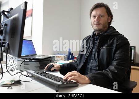 PRODUKTION - 17. Dezember 2021, Niedersachsen, Göttingen: Thomas Bode, Leiter der Schuldenberatung der AWO Göttingen, sitzt in seinem Büro am Computer. (To dpa: ''Es kann jeden treffen' - Schuldenberatung hilft in der Corona Times') Foto: Swen Pförtner/dpa Stockfoto