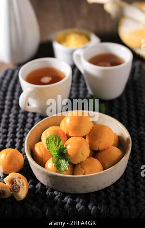 Nastar Durian, Kekse mit Durian-Konfitüre, serviert in einer braunen Schüssel mit Minzblatt als Garnierung Stockfoto