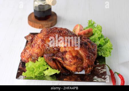 Würziger Honig gebratenes Hähnchen auf weißem Teller. In Indonesien beliebt als Ayam Bakar Bumbu rujak. Stockfoto