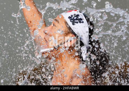 Tokio, Japan. 15th Januar 2022. Ein Teilnehmer, der nur in Lendenschurz gekleidet ist, gießt kaltes Wasser über sich selbst während der traditionellen Zeremonie zur Reinigung der kalten Ausdauer (Kanchu-Misogi) im Kanda Myojin-Schrein. In diesem Jahr trotzten rund 20 Teilnehmer dem Eisbad-Ritual, einer traditionellen Zeremonie, die dafür bekannt ist, die Seele zu reinigen und Viel Glück. zu bringen (Bild: © Rodrigo Reyes Marin/ZUMA Press Wire) Bild: ZUMA Press, Inc./Alamy Live News Stockfoto