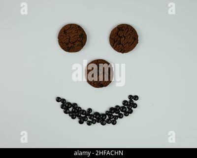 Kreatives Foto von Chocolate Chip Cookies, die ein lächelndes Gesicht bilden. Stockfoto