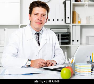 Zahnarzt, der im medizinischen Zentrum am Laptop arbeitet Stockfoto