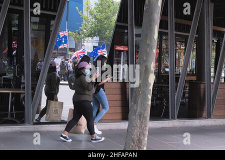 Melbourne, Australien, 15. Januar 2022. Zwei Frauen Filmen Protestierende auf ihrem Handy, während sie während eines geplanten protestmarsches vorbeigehen, der von der Gruppe Reclaim the Line organisiert wird, die Impfmandate und andere Gesundheitsmaßnahmen von Staats- und Bundesregierungen ausgibt. Quelle: Michael Currie/Speed Media/Alamy Live News Stockfoto