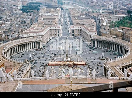 Ein Blick von der Kuppel des Petersdoms, Vatikanstadt, Italien auf den Petersplatz in c. 1960. Viel mehr Verkehr war damals auf dem platz erlaubt. Im Hintergrund ist die breite Straße, die Via della Conciliazione, die Hauptverkehrsstraße nach Rom. Die päpstliche Basilika St. Peter im Vatikan ist eine Kirche im Renaissance-Stil in der Vatikanstadt, der päpstlichen Enklave, die sich innerhalb der Stadt Rom befindet. Dieses Bild stammt von einem alten Amateur 35mm Farbtransparenz – ein Vintage 1950/60s Foto. Stockfoto