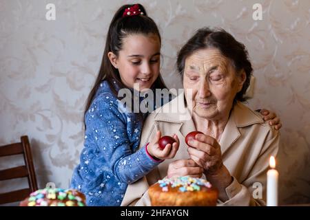 Ältere Frau mit ostereiern und Osterkuchen Stockfoto