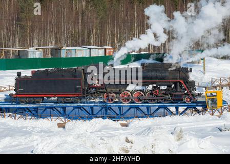 Alte sowjetische Hauptverkehrsdampflokomotive L-2198 auf einem Wendekreis an einem Märznachmittag. Ruskeala Mountain Par Stockfoto