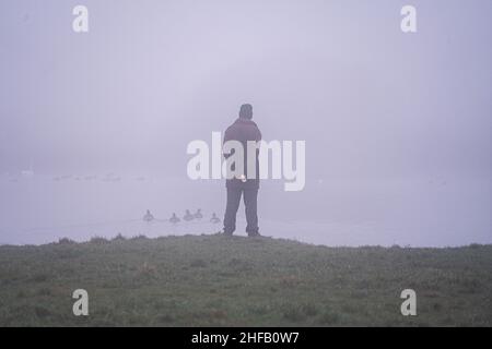 London, Großbritannien. 15. Januar 2022. Menschen in dichtem, eisigen Nebel heute Morgen auf Wimbledon Common, SW London. Das Met Office hat eine gelbe Wetterwarnung für Nebel in einigen Teilen Südostenglands mit schlechter Sicht herausgegeben.Quelle: amer ghazzal/Alamy Live News Stockfoto