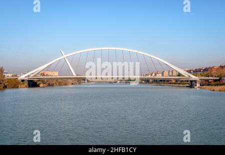 Panoramablick auf die Barqueta-Brücke, eine gebundene Bogenbrücke, die den Alfonso XII-Kanal des Guadalquivir-Flusses in Sevilla, Andalusien, Spanien überspannt. Stockfoto