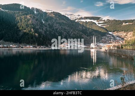 Uzungol Lake in Trabzon während der Wintersaison. Schnee auf dem Berggipfel, Reflexion der Moschee und ihres Minaretts auf dem Wasser des Uzungol Stockfoto