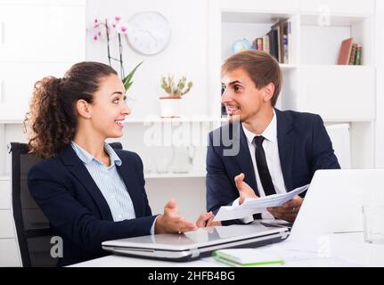 Porträt von Geschäftskollegen, die sich über die Arbeit im Büro unterhalten Stockfoto