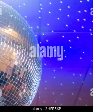 Giant Mirror Ball reflektiert Lichtpunkte an der blauen Decke Stockfoto