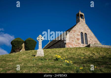 Linton Kirk, in der Nähe von Moreschlacht, Kelso, Scottish Borders. Mit einem keltischen Kreuz-Denkmal und Narzissen am ersten Apriltag. Stockfoto