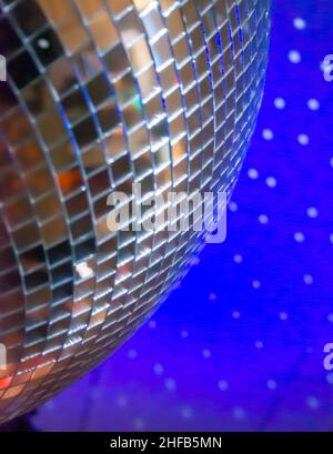 Giant Mirror Ball reflektiert Lichtpunkte an der blauen Decke Stockfoto