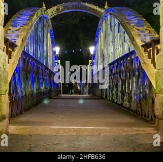 Jubilee Bridge 1887 mit farbiger Beleuchtung für die viktorianischen Illminationen in Matlocak Bath beleuchtet. Stockfoto