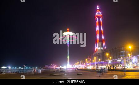 Blackpool Tower mit einer sich drehenden Fahrt auf dem Jahrmarkt, die von den Illuminations beleuchtet wird Stockfoto