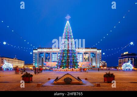 Weihnachtsbaum, Beleuchtung und Dekoration vor dem Gebäude des Palastes der Republik auf dem Oktyabrskaja-Platz in Minsk, Weißrussland. Stockfoto