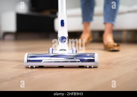 Junges Mädchen Bodenreinigung mit Handstaubsauger Stockfoto