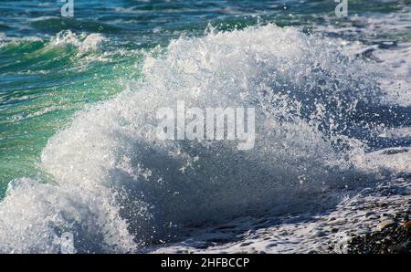 Blaue Welle bricht an einem Strand im Meer. Stockfoto
