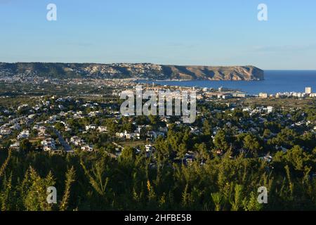 Blick über Häuser und Villen auf den Hafen und die Bucht von Javea an der Costa Blanca, mit Landzunge von Cabo San Antonio dahinter, Provinz Alicante, Spanien Stockfoto
