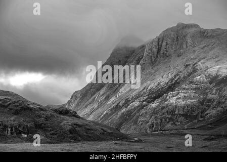 Schwarz-Weiß Epische Landschaft mit Sonnenaufgangslicht über Blea Tarn im Lake District mit atemberaubendem Licht auf fernen Bergen Stockfoto