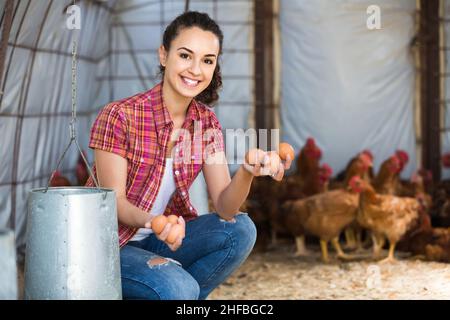 Porträt einer jungen Bäuerin, die frische Eier in den Händen in einem Hühnerstall hält Stockfoto