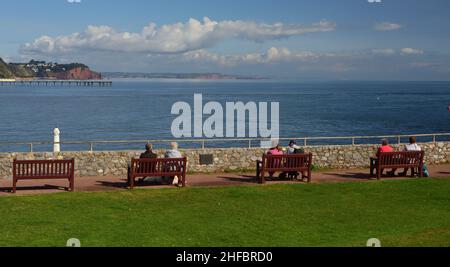 Menschen genießen den Meerblick von Shaldon, South Devon, mit Blick auf Teignmouth und den entfernten Hole Head. Stockfoto