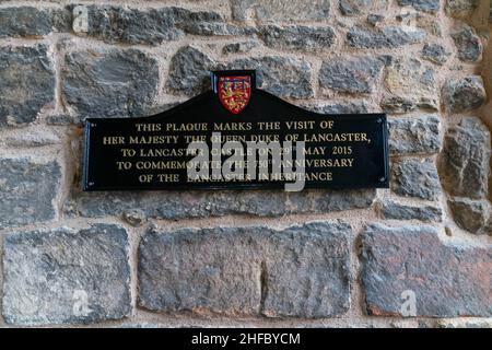 Plakette am Eingang zum Schloss Lancaster, im Besitz des dienenden Monarchen, Königin Elizabeth II. Die römische Festung wurde während der Engländer als Gefängnis benutzt Stockfoto