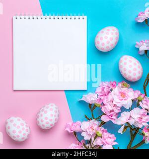 Osterhintergrund mit Ostereiern mit Punktmuster, pastellrosa Papiervorlage, Grußkarte mit Platz für Text. Frühjahrssaison. Festliche flache Laie, Mo Stockfoto