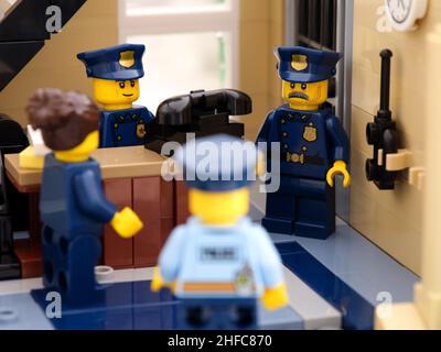 Tambow, Russische Föderation - 02. August 2021 vier Lego-Polizisten, die in der Nähe eines alten Telefons in einer Polizeistation eine Diskussion führen. Stockfoto