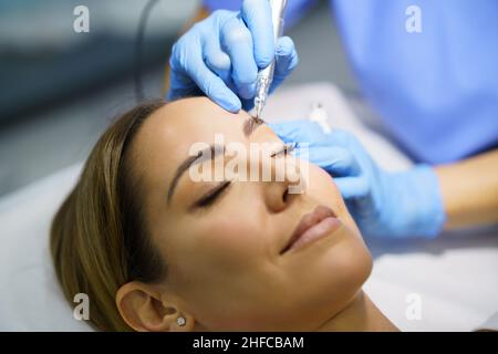 Permanentes Make-up für Augenbrauen einer schönen Frau in einem Schönheitssalon. Behandlung von Mikropigmentierungen. Stockfoto