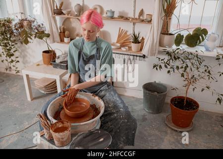 Weibliche Kunsthandwerkerin konzentrierte sich auf die Modellierschale im Arbeitszimmer Stockfoto