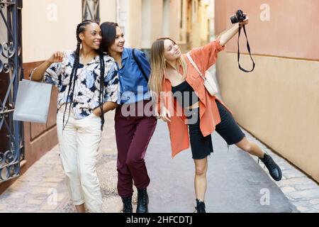 Fröhliche, vielfältige Damen, die während ihrer Reise in die Stadt Selfie vor der Kamera machen Stockfoto