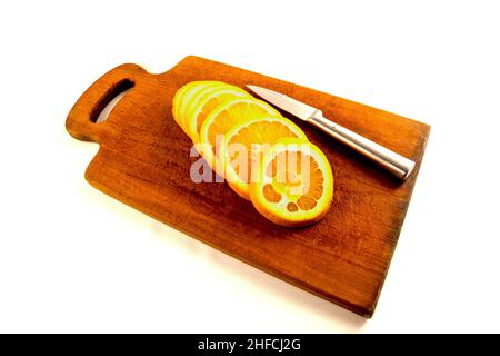 Orangen auf einem Schneidebrett mit einem Messer isoliert auf weiß Stockfoto