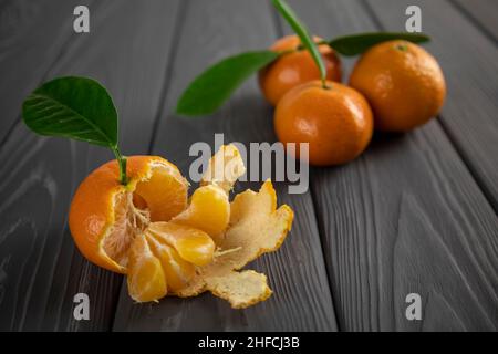Mandarine mit Blatt auf einem Holztisch. Unscharfer Hintergrund. Stockfoto