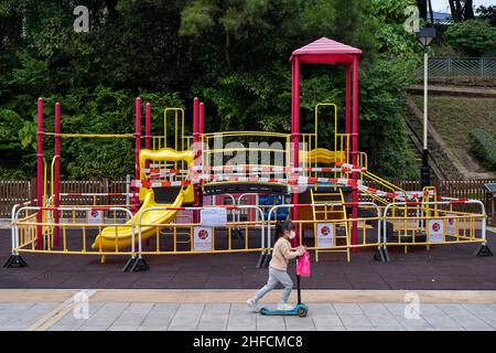 Ein Kind fährt auf einem Elektroroller an einem geschlossenen Spielplatz in Hongkong vorbei.die Regierung Hongkongs führte erneut strengere soziale Beschränkungen von Covid ein, die Unternehmen und öffentliche Orte dazu zwingen, mindestens nach dem chinesischen Neujahrsfest (CNY) und den Feierlichkeiten die Schließung zu unterbinden, um die Ausbreitung der Omicron-Variante als die zu kontrollieren Die Strategie der Regierung zielt weiterhin auf eine Null-Infektion in der Stadt ab. (Foto von Miguel Candela / SOPA Images/Sipa USA)