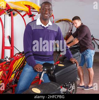 Afroamerikanischer Mann, der einen Rikscha-Fahrradservice anbietet Stockfoto