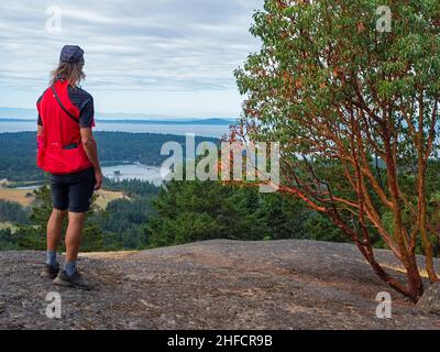 WA21134-00...WASHINGTON - Radsportler vom Gipfel des Young Hill aus über die Garrison Bay mit der Haro Strait, Vancouver Island und Olympic Mtns. Stockfoto