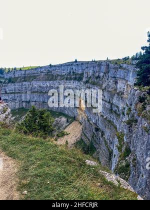 Der Blick auf die beeindruckende Felsformation des Creux-du-Van in der Schweiz Stockfoto