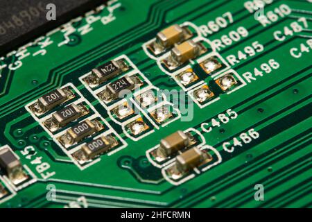 SMD-Widerstände und Kondensatoren, die auf einer grünen Leiterplatte (PCB) gelötet sind. Stockfoto