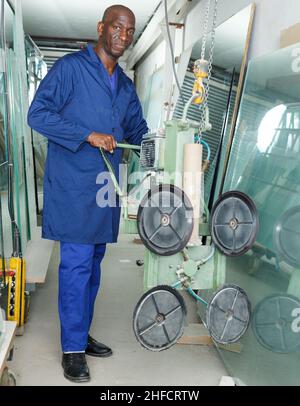 Arbeiter mit Vakuumgläserheber Stockfoto